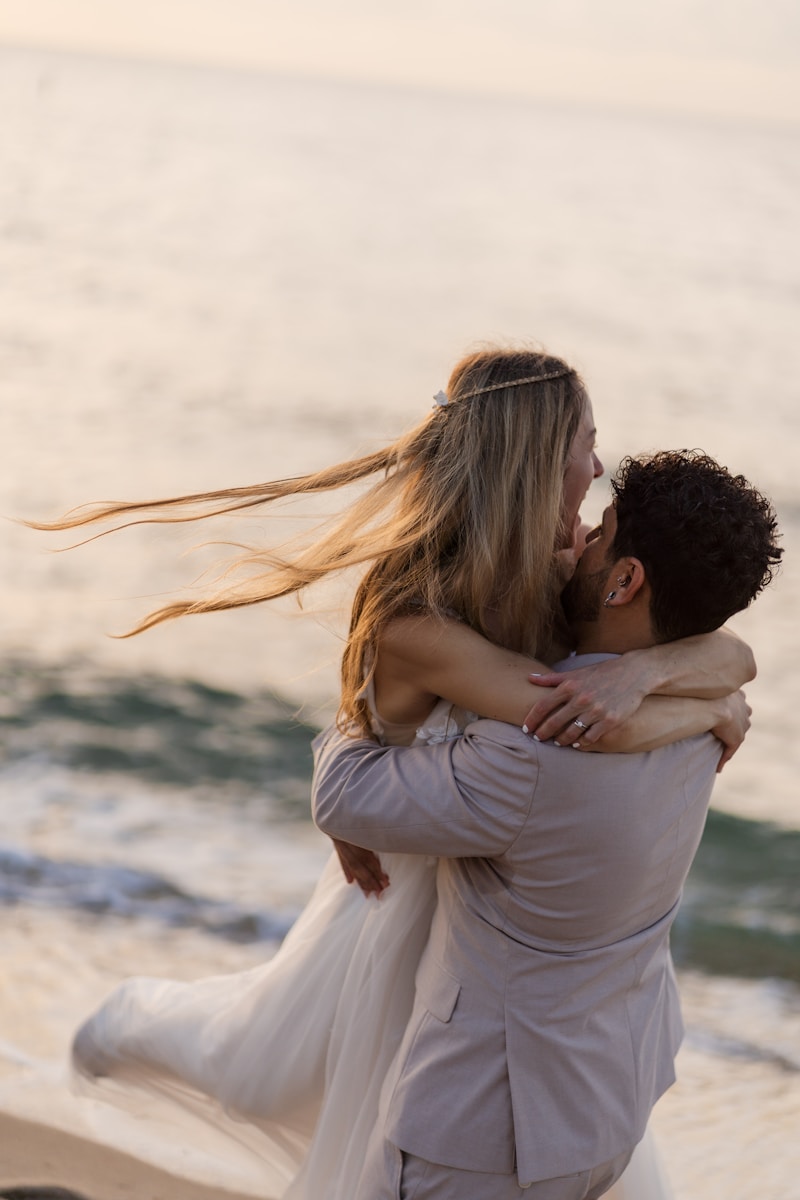 A couple embraces and kisses at the beach.